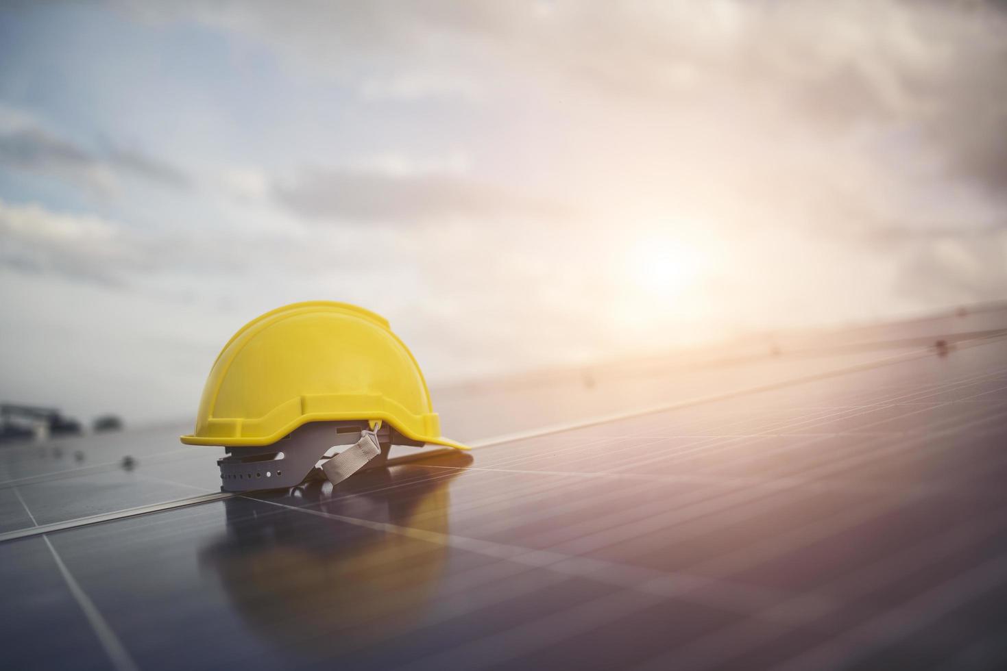 gelber Schutzhelm auf Solarpanel foto