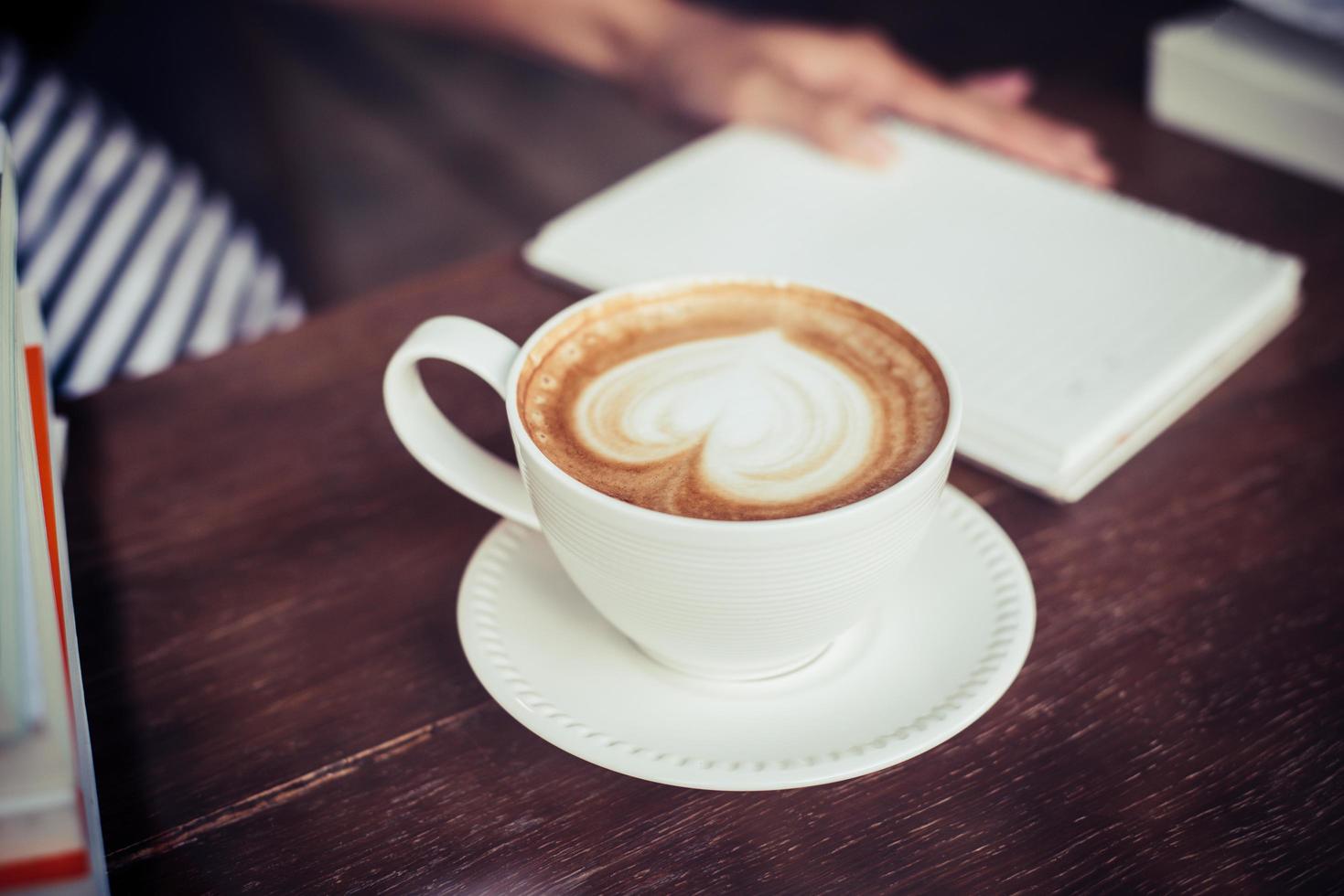 Frauenhände, die mit Kaffee im Café entspannen foto
