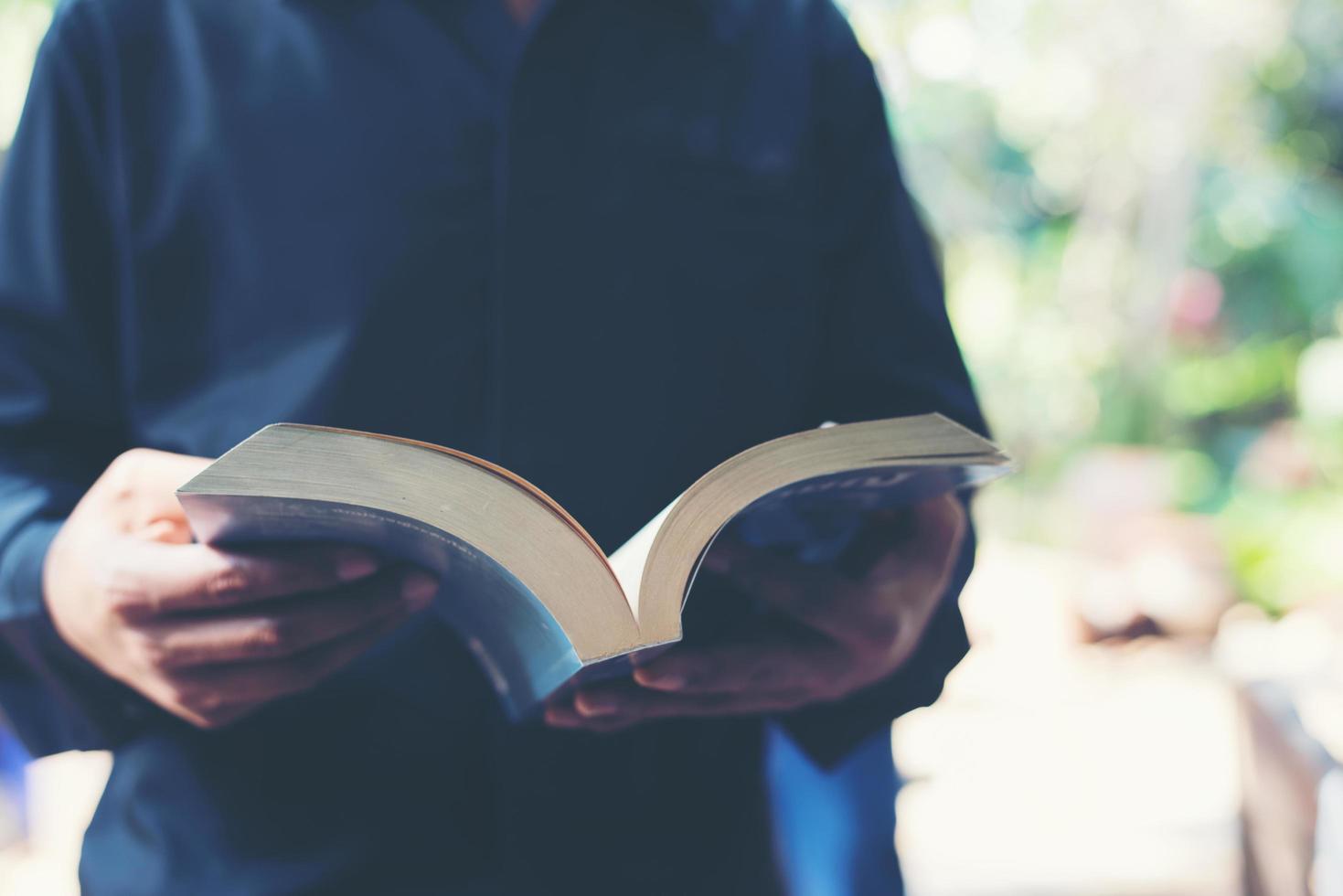 Mann liest ein Buch in seinen Händen foto