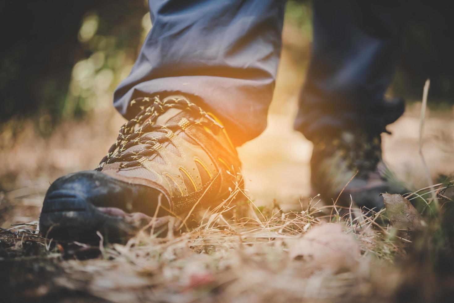 Nahaufnahme der Füße eines Mannes, die auf einem Bergweg wandern foto