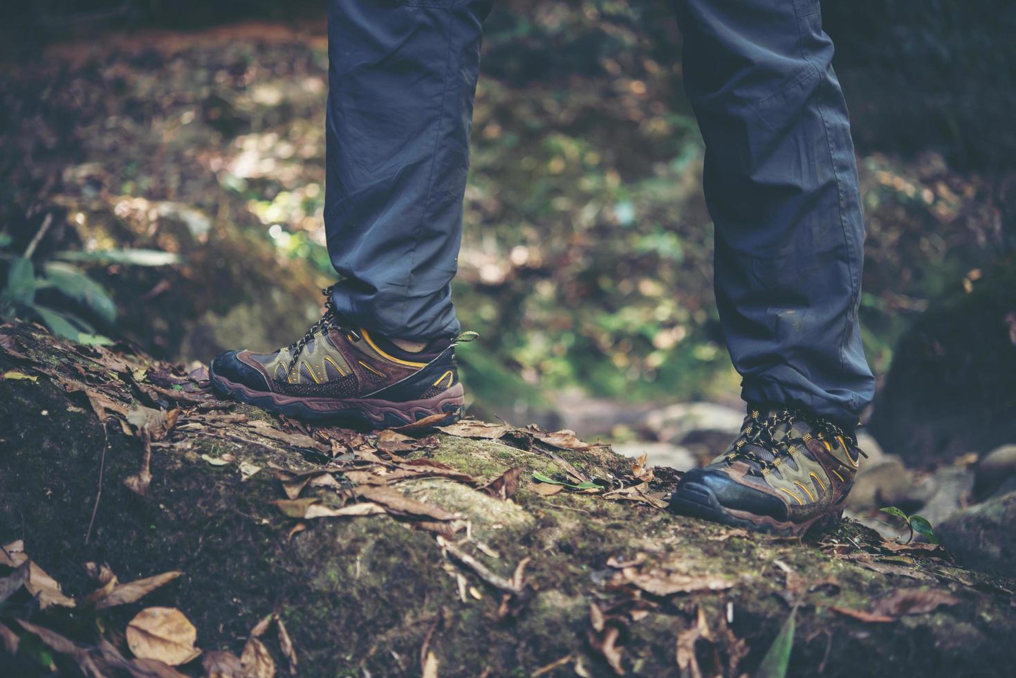 Nahaufnahme der Füße eines Mannes, die auf einem Bergweg wandern foto