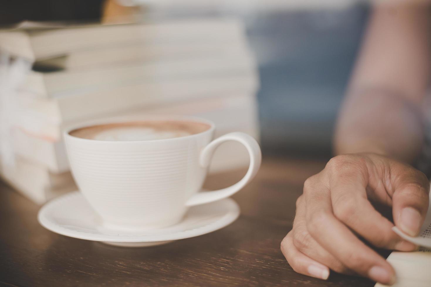 Frauenhände, die mit Kaffee im Café entspannen foto