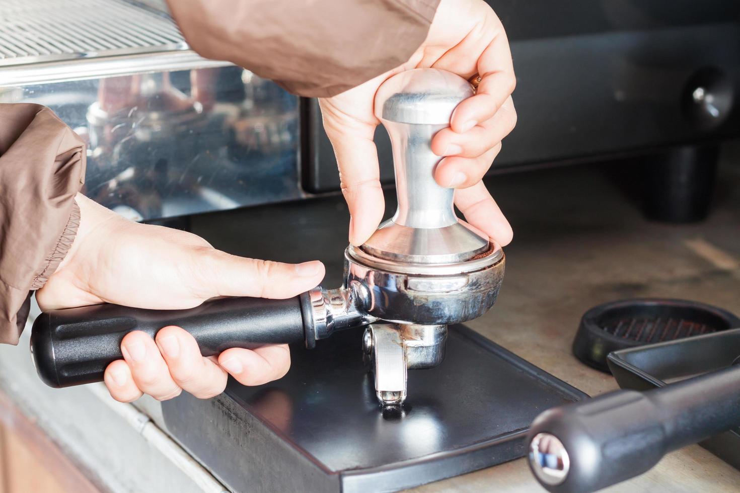 Barista mit einem Stampfer für die Zubereitung von Espresso foto