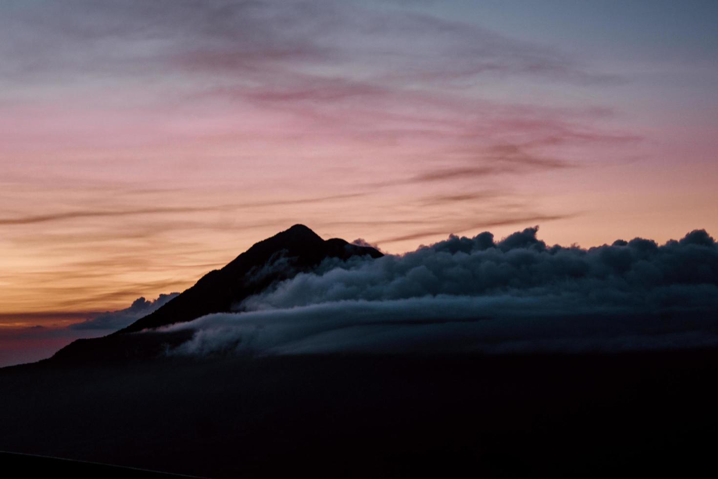 Wolken bedecken einen Berg foto