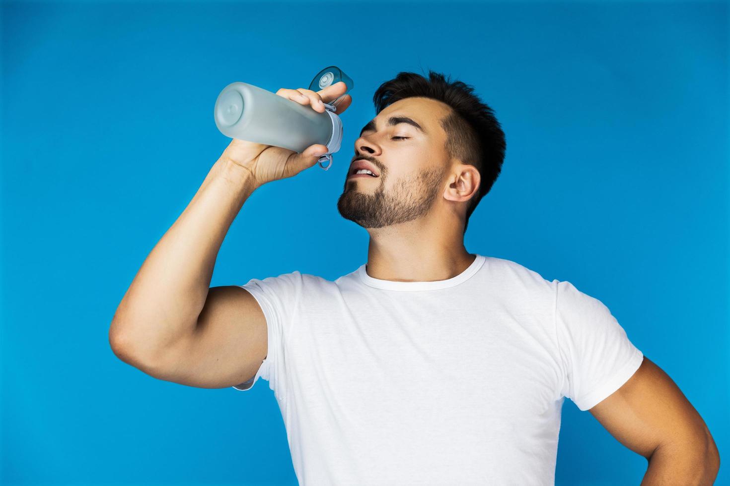 Mann trinkt aus Wasserflasche foto