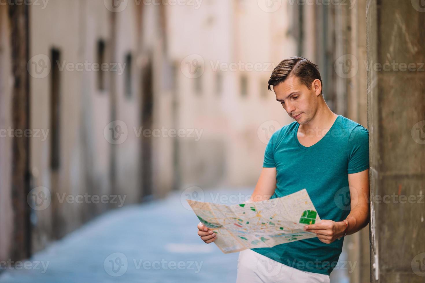 junger mann mit einem stadtplan in einer europäischen stadt. foto