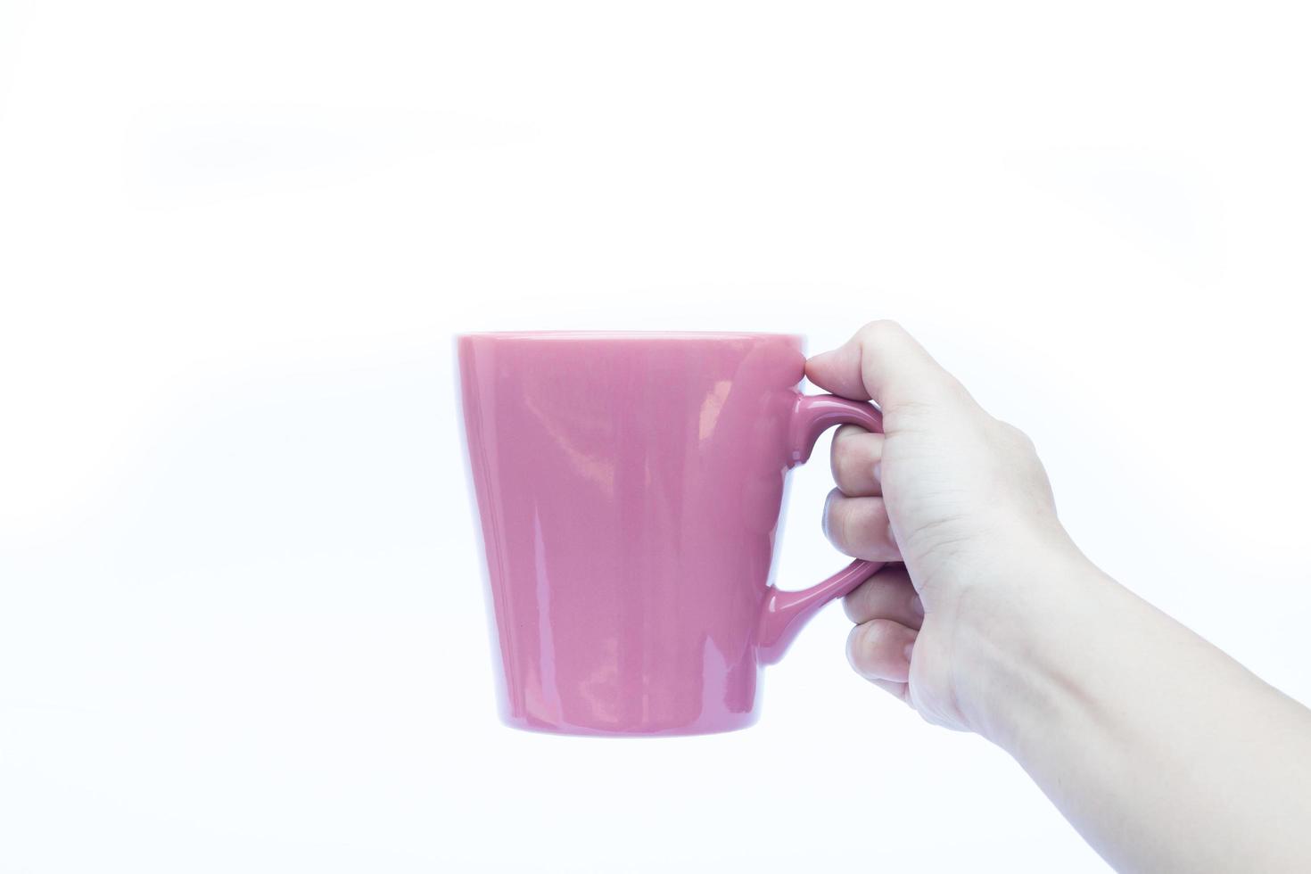 Hand hält eine rosa Tasse foto