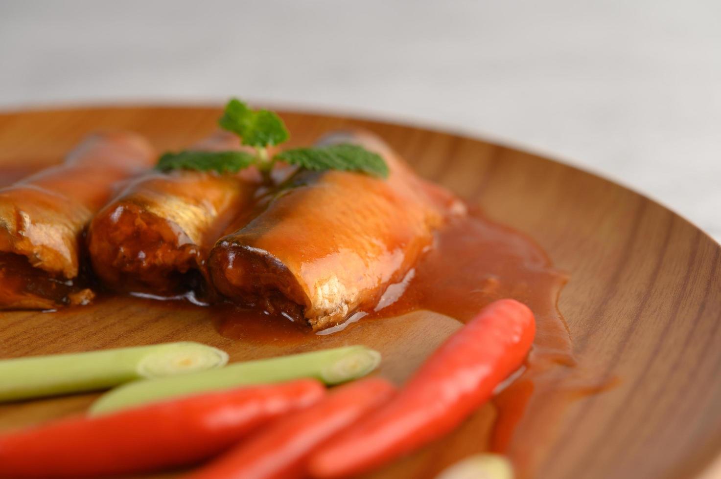 Sardinen in Tomatensauce auf einem Holztablett foto