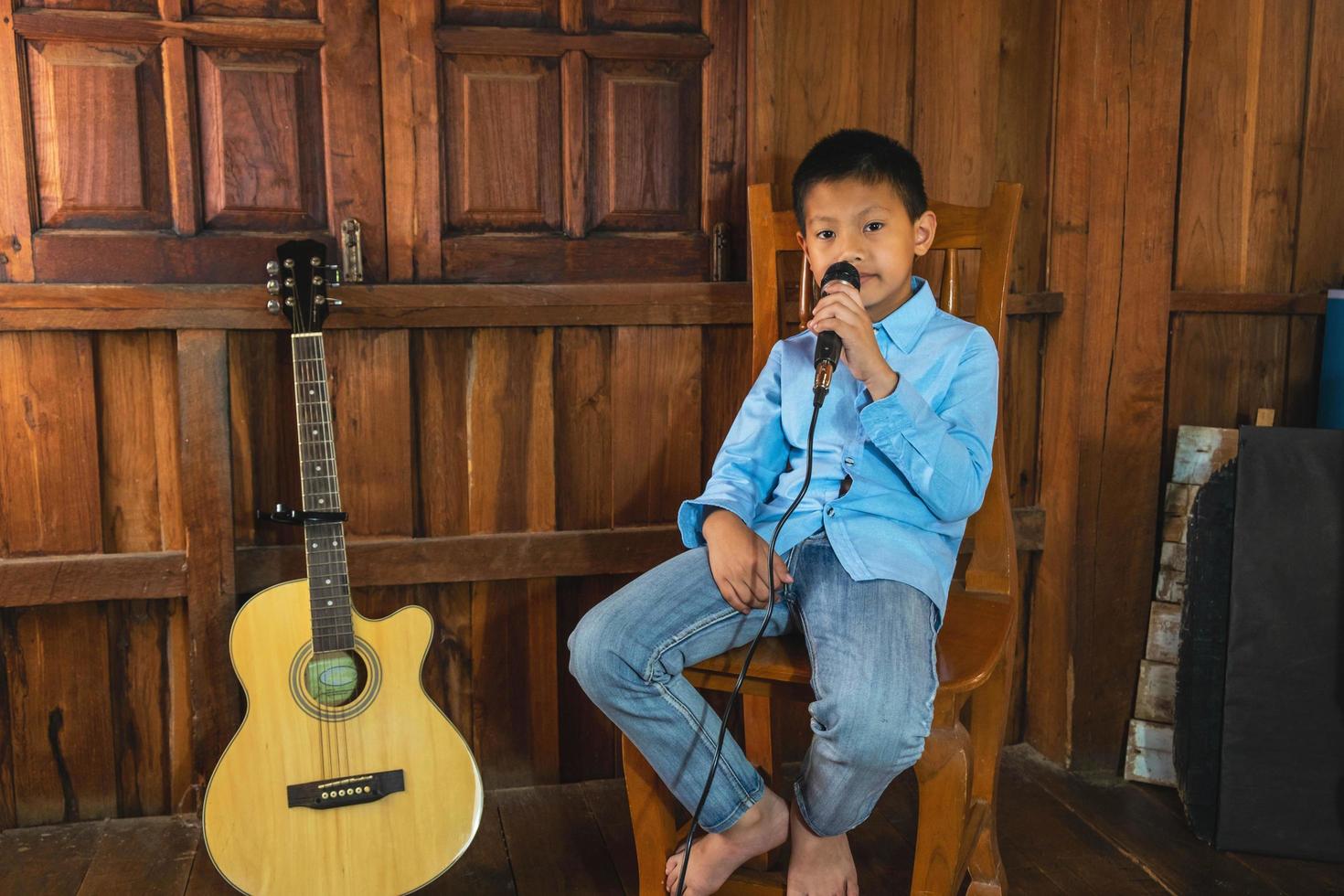 Junge singt im Sitzen foto