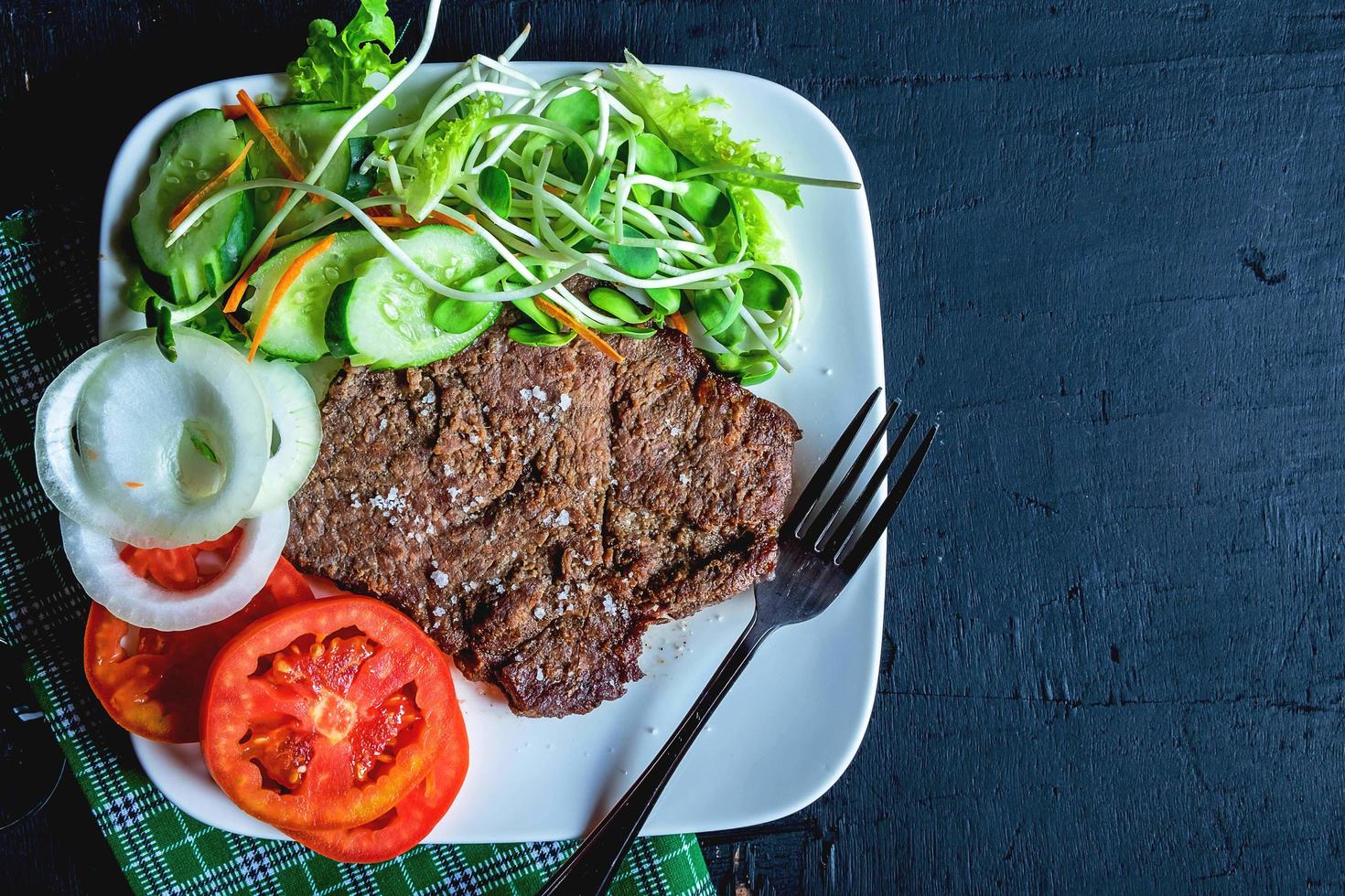 Steak mit Gemüse auf einem weißen Teller foto