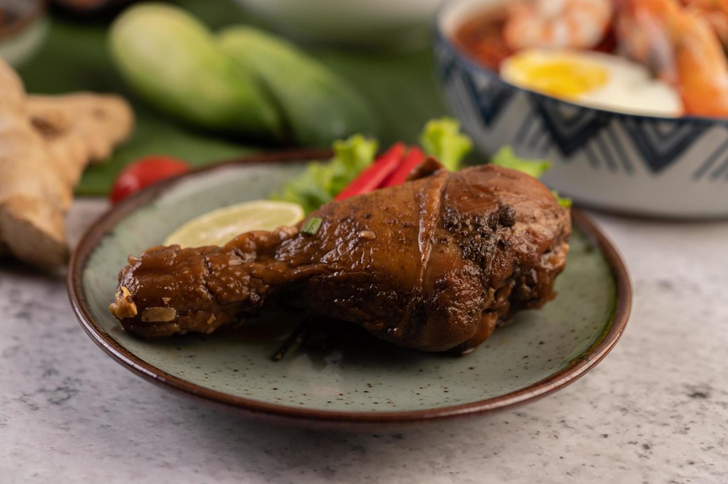 Geschmorte Hähnchenschenkel mit Salat, Chili und Limette foto