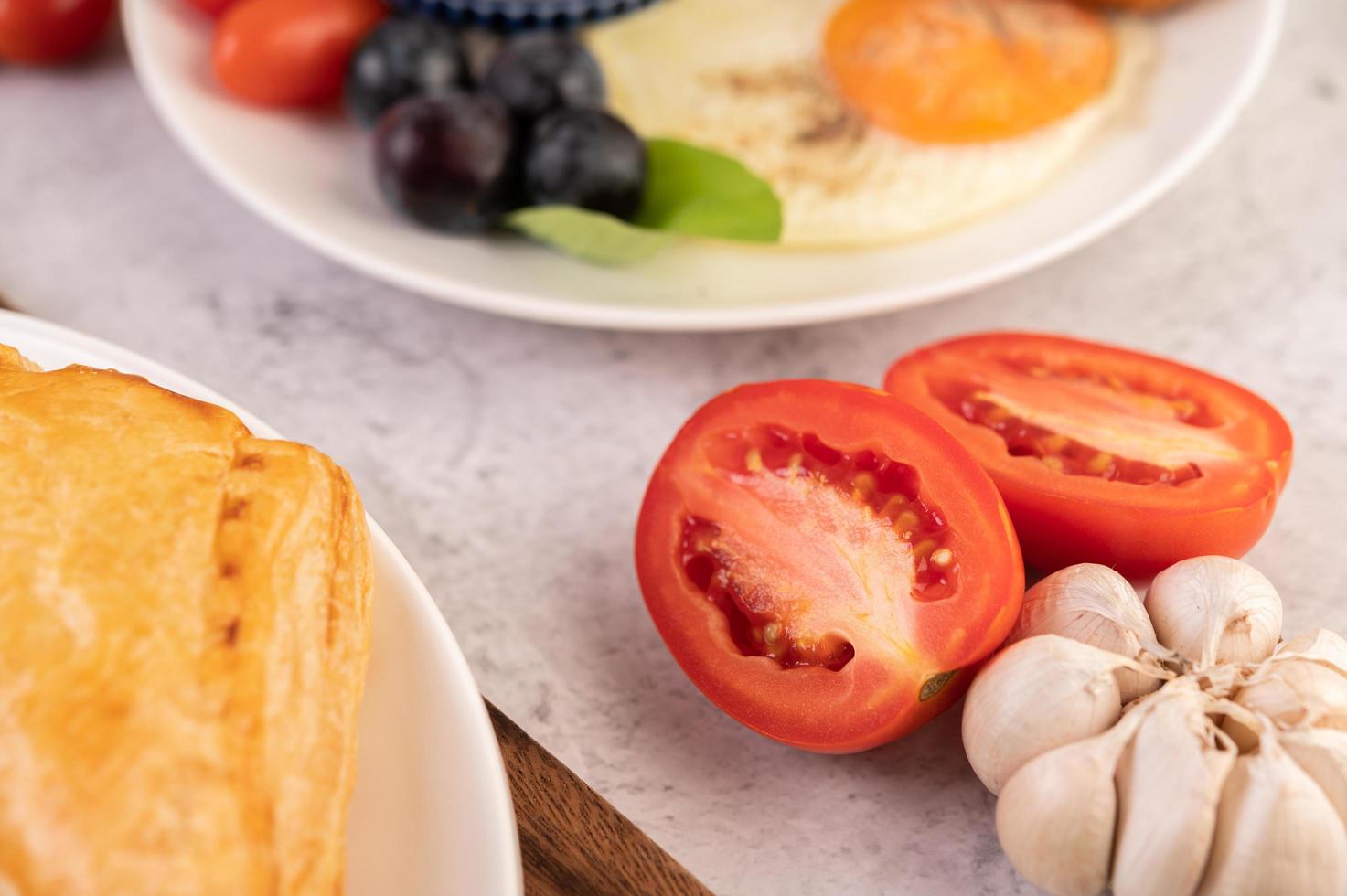 halb geschnittene Tomaten und Brot mit Knoblauch foto