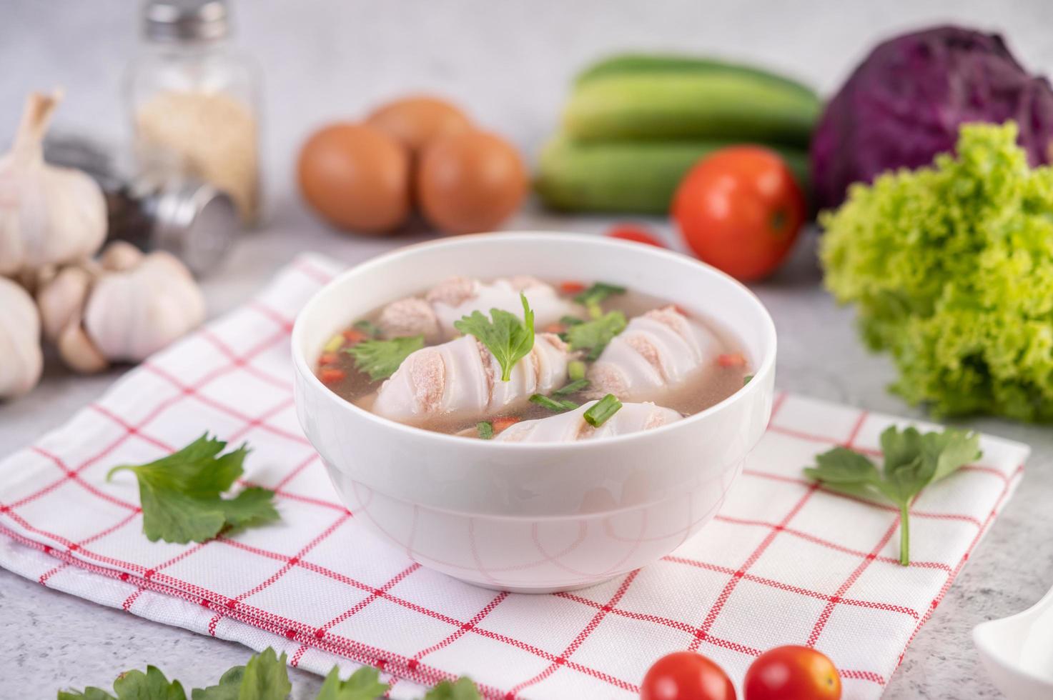 weiße Schüssel Tintenfischsuppe mit Schweinefleisch und Frühlingszwiebeln foto