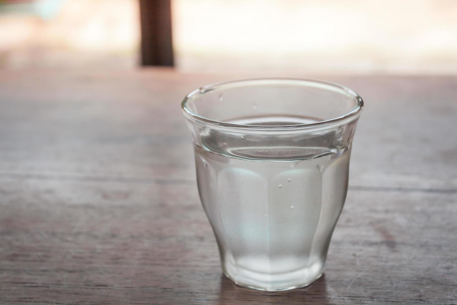 Wasser in einem Glas auf einem Tisch foto