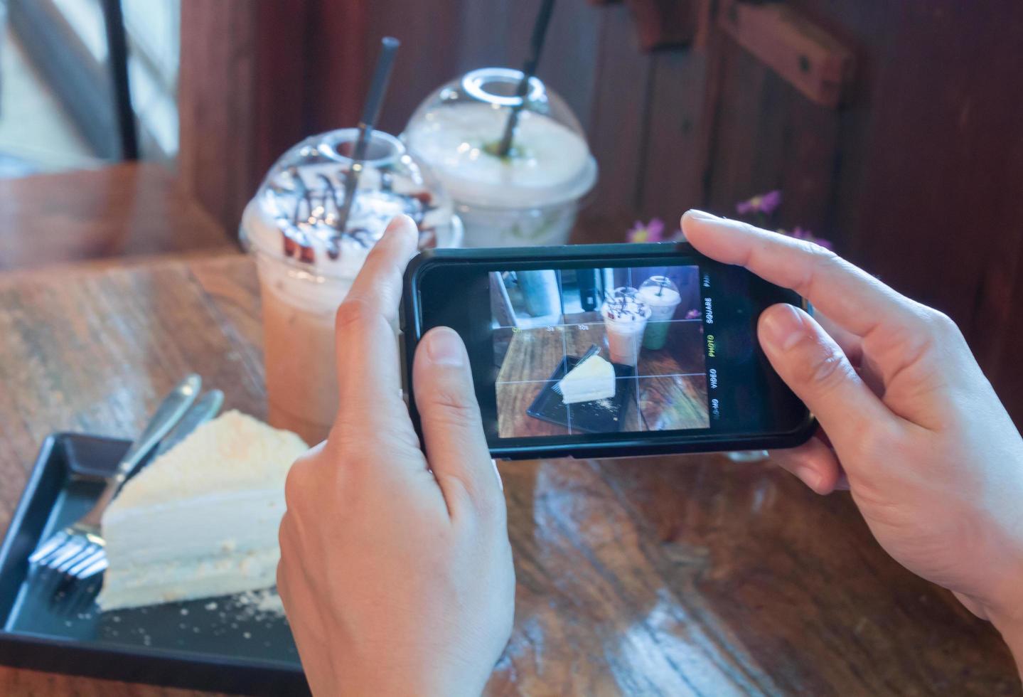 Person, die ein Foto von Kuchen und Kaffee macht