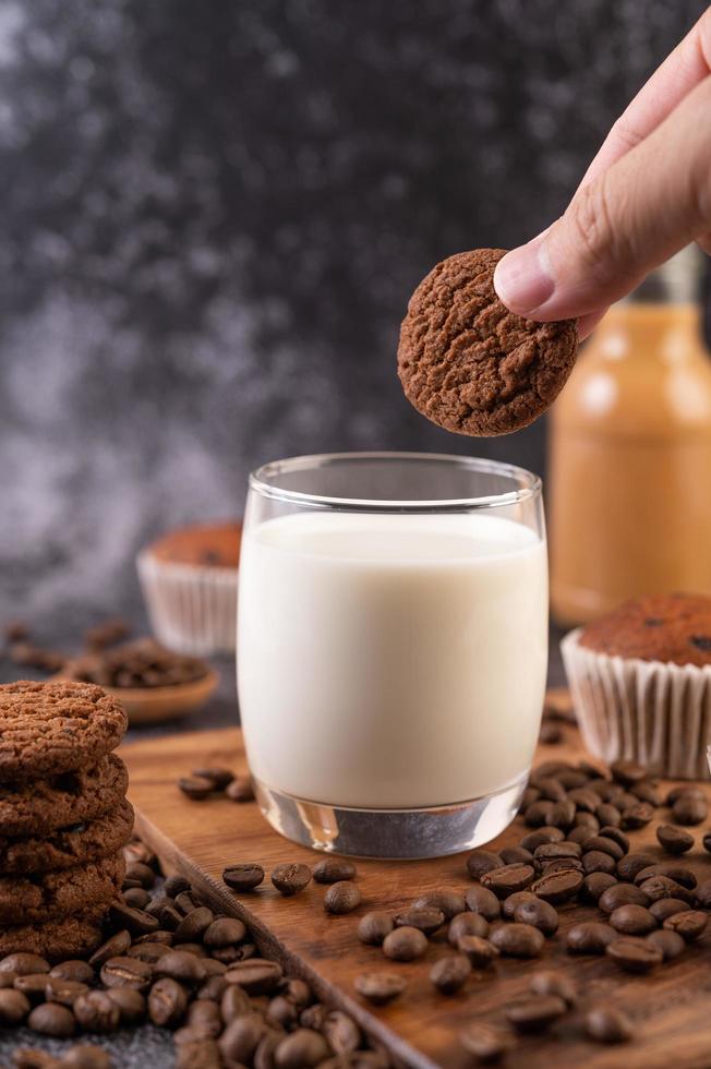 Hand, die einen Keks in Milch taucht foto