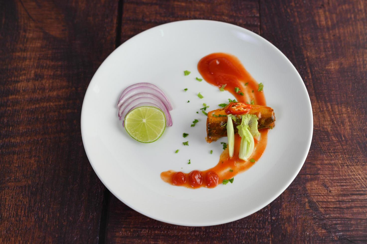 Sardinen mit Tomatensauce auf einem weißen Teller foto