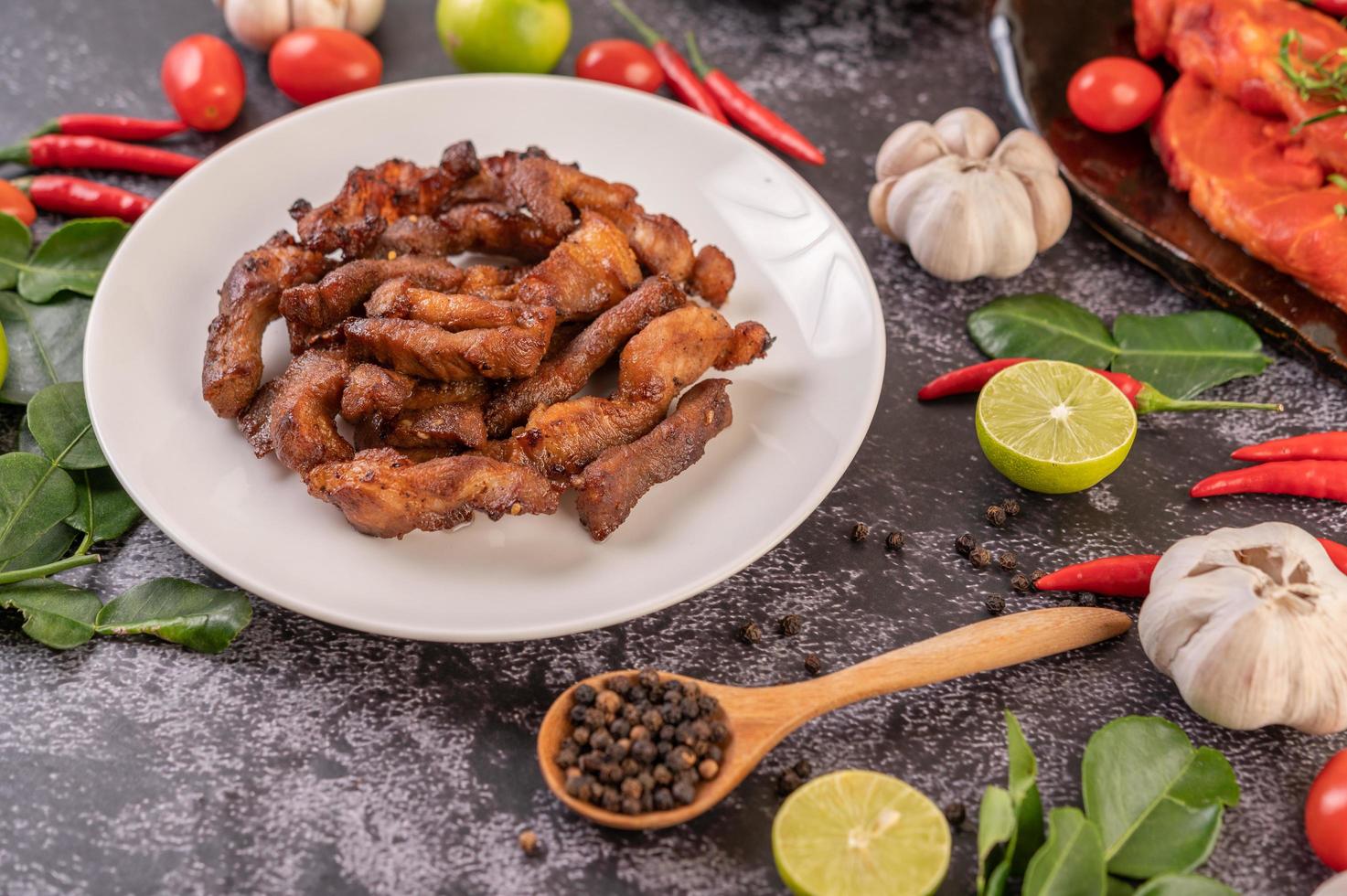 Schweinekotelett auf einem weißen Teller auf schwarzem Tisch foto