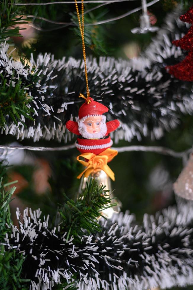 Nahaufnahme des Weihnachtsmannes, der vom Weihnachtsbaum hängt foto