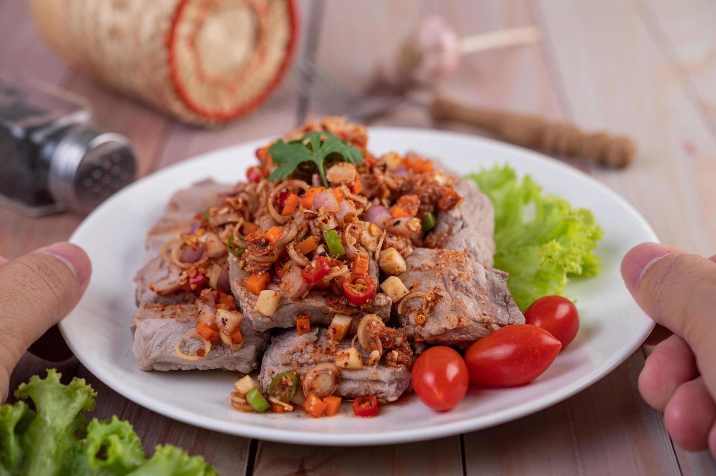 würziges Schweinefleisch mit Tomaten gehackt foto