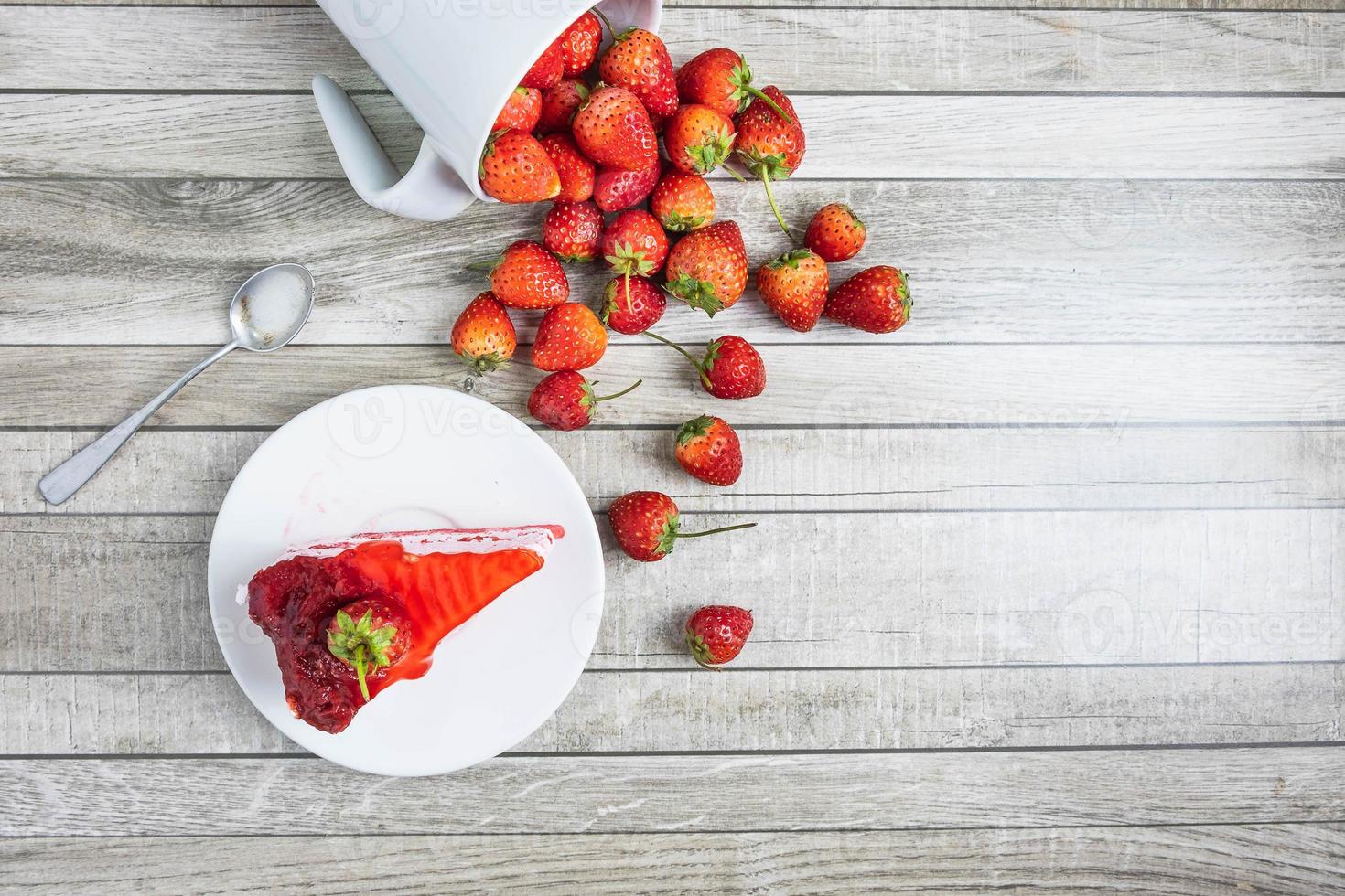 Tasse Erdbeeren mit einem Kuchen foto
