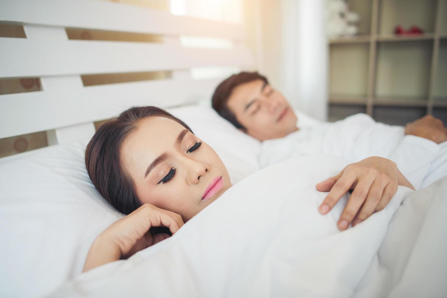 glückliches Paar, das zusammen in ihrem Bett liegt foto