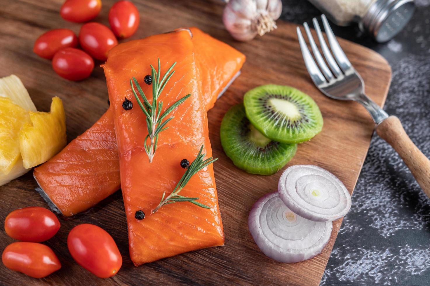 rohe Lachsfilets mit Pfeffer, Kiwi, Ananas und Rosmarin foto