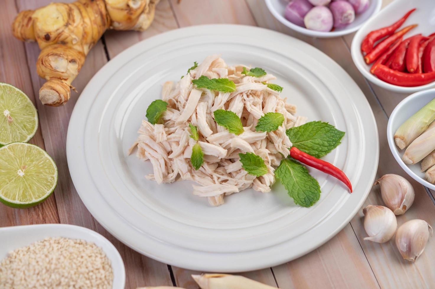 Hühnersalat auf einem weißen Teller mit Minzblättern foto