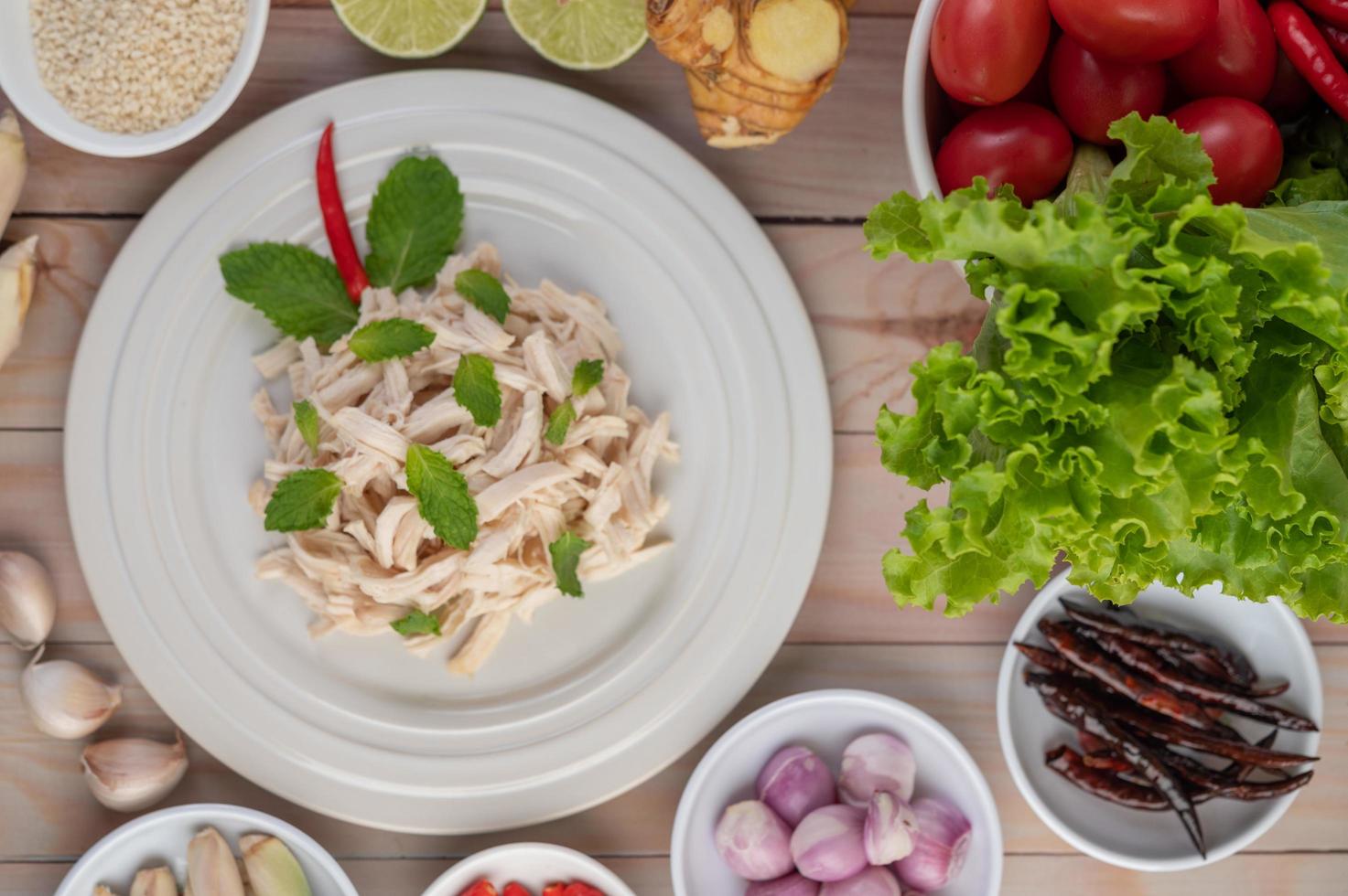 Hühnersalat auf einem weißen Teller mit Minzblättern foto