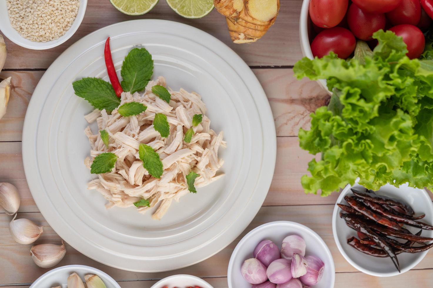 Hühnersalat auf einem weißen Teller mit Minzblättern foto