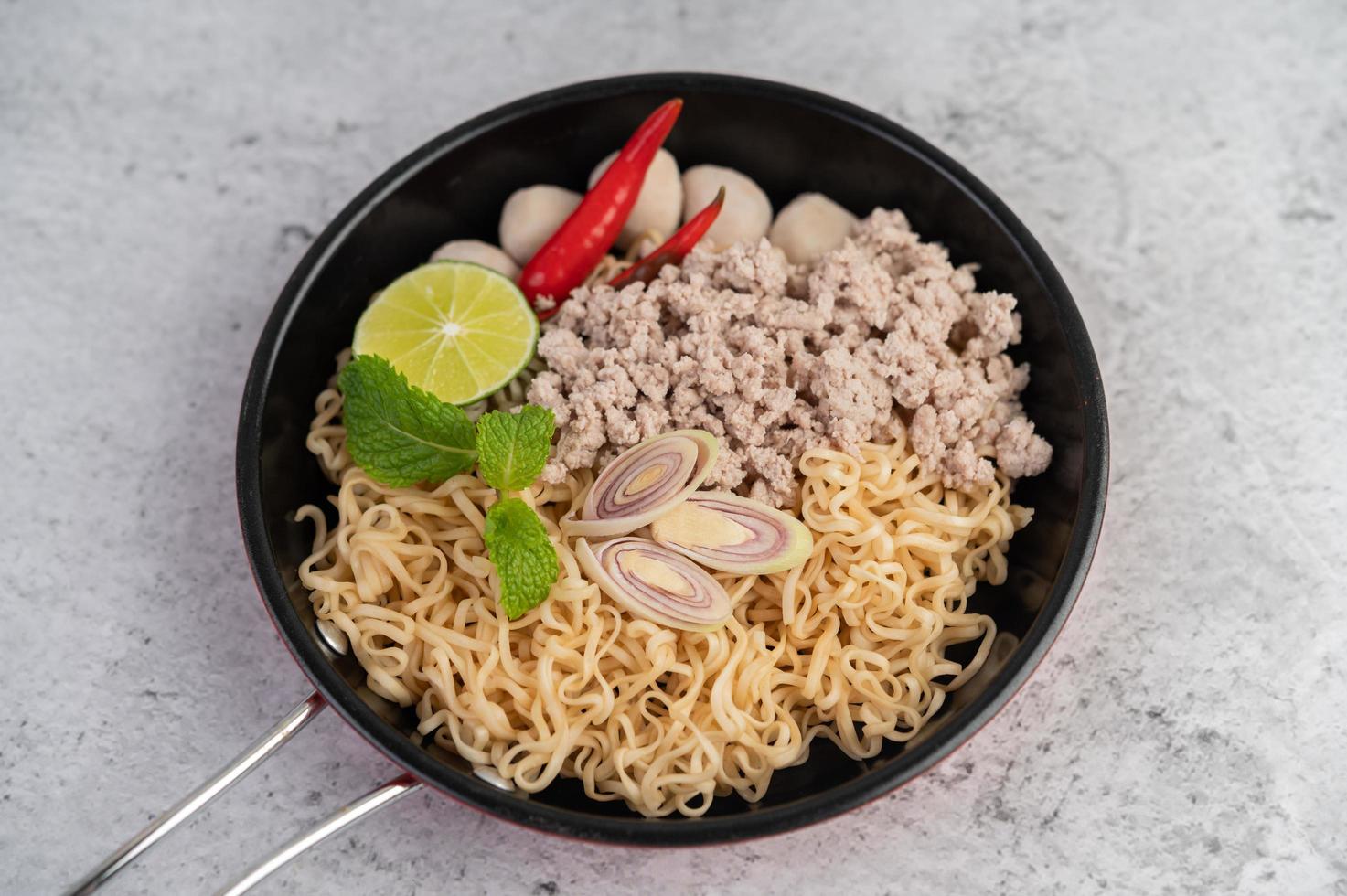 gehacktes Schweinefleisch in einer Pfanne mit Limette, Chilis und Fleischbällchen foto