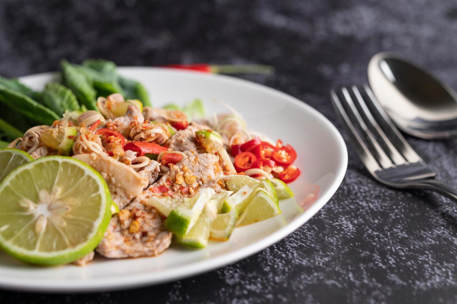 würziger Limettenschweinefleischsalat mit Gemüse und Beilagen foto