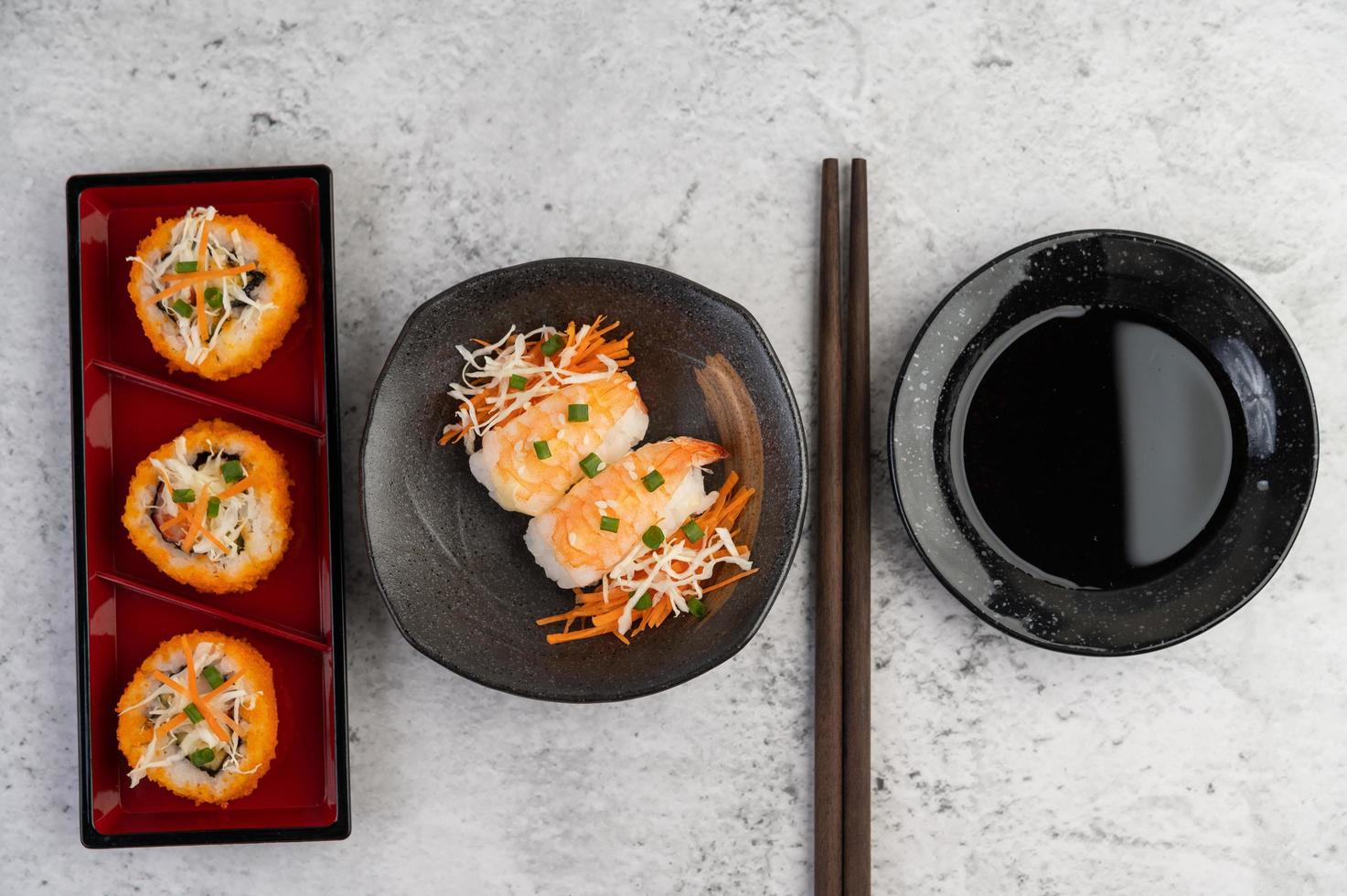 plattiertes Sushi mit Sauce und Essstäbchen foto