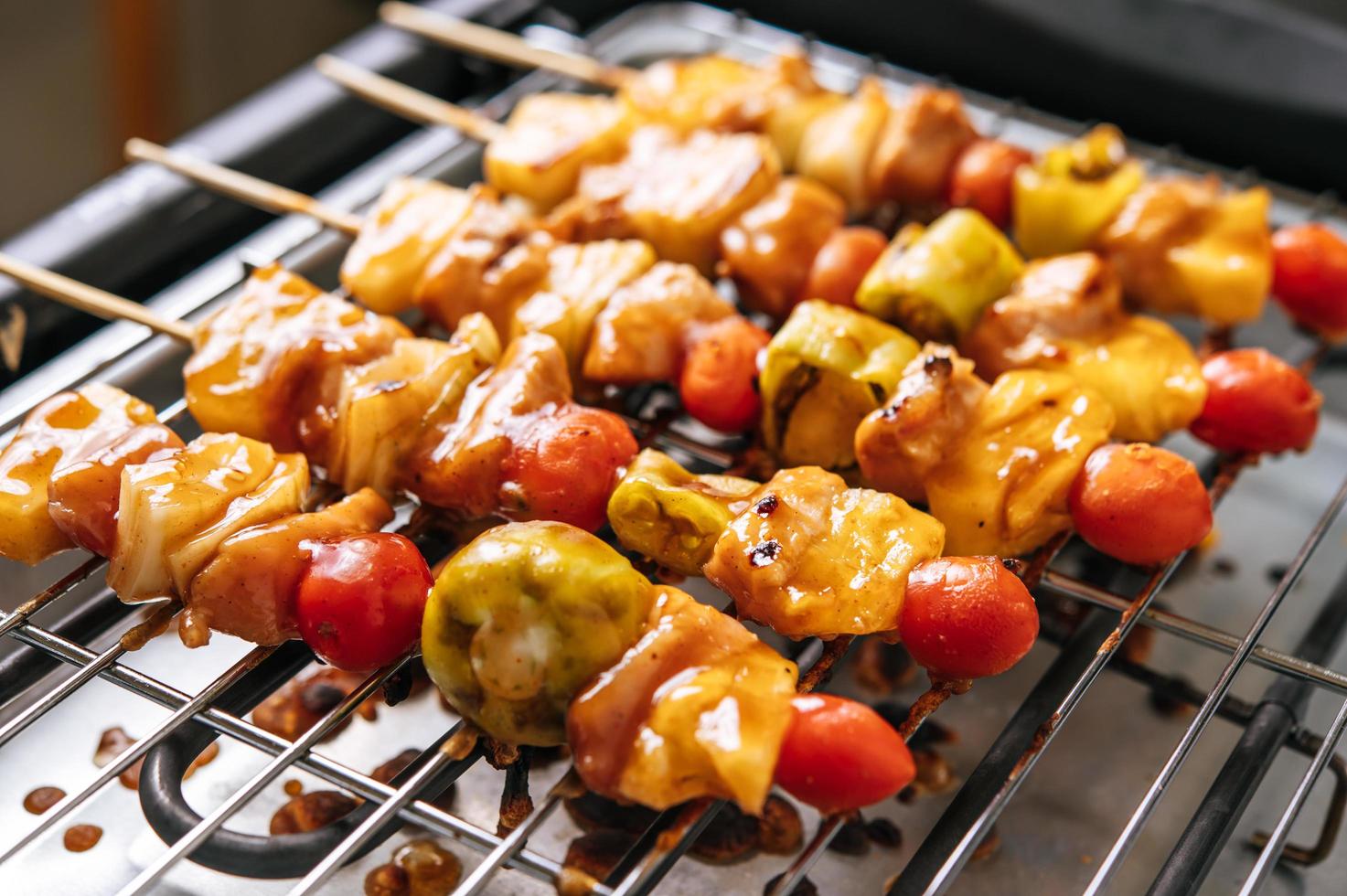 Grill mit einer Vielzahl von Fleisch, Tomaten und Paprika foto