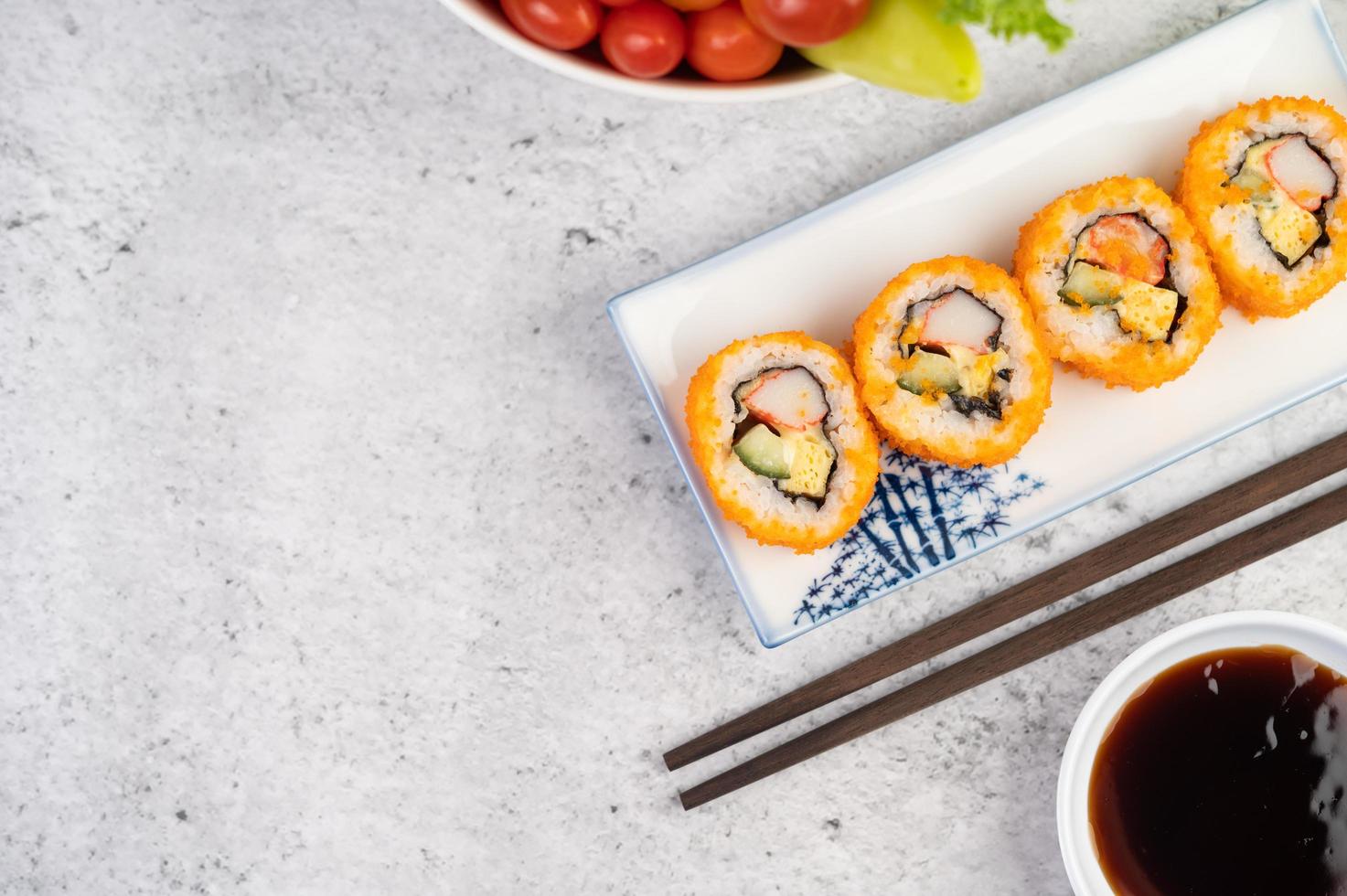 plattiertes Sushi mit Sauce und Essstäbchen foto