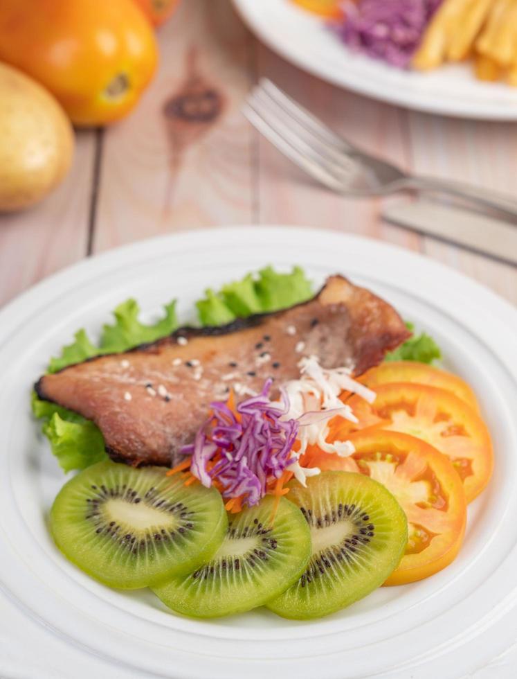 Fischsteak mit Pommes Frites, Obst und Gemüse foto