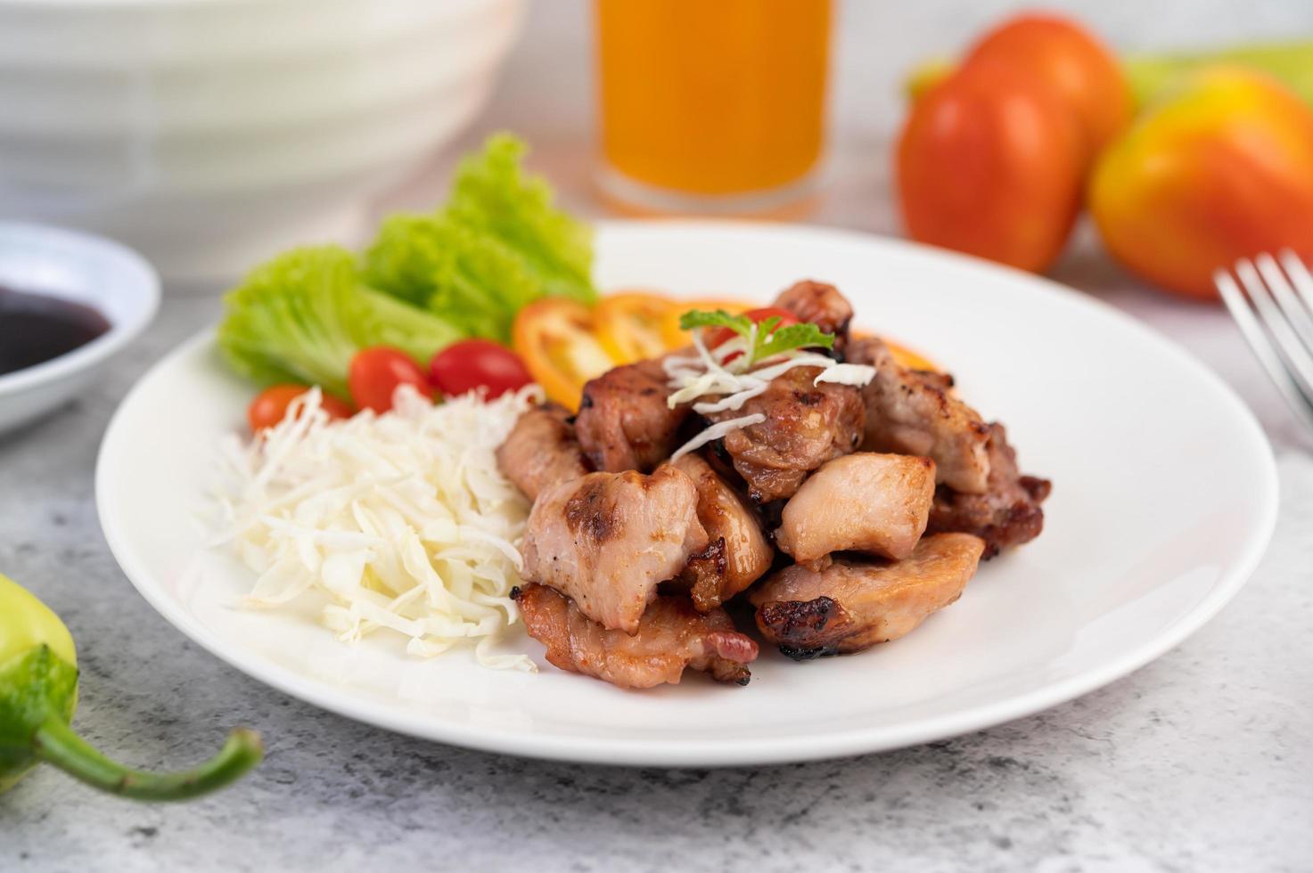 Gegrilltes Schweineschnitzel mit Tomaten und Salat foto