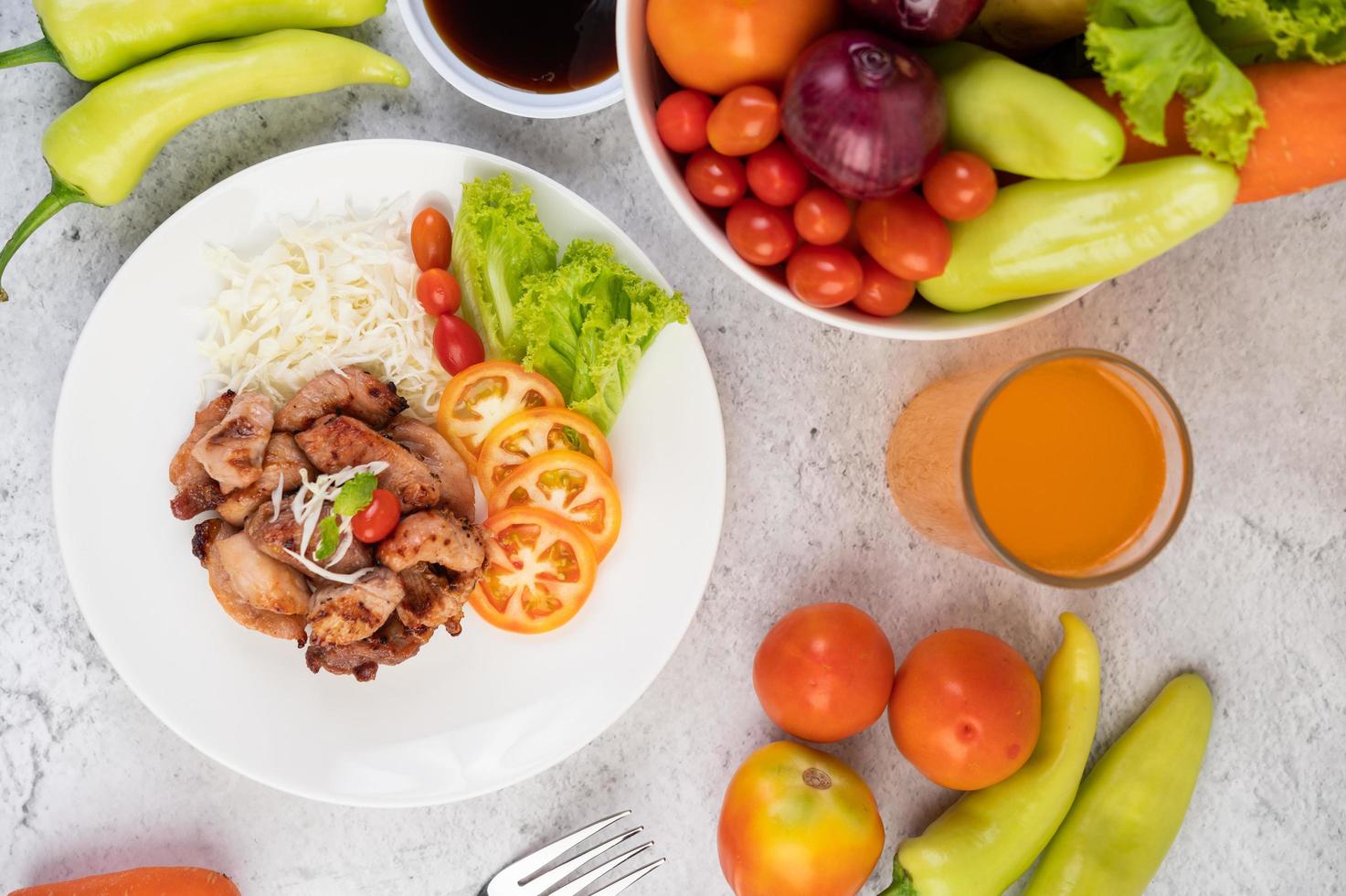 Gegrilltes Schweineschnitzel mit Tomaten und Salat foto