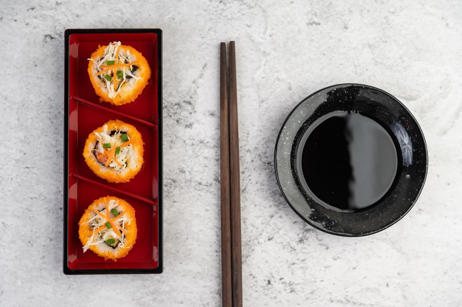 plattiertes Sushi mit Sauce und Essstäbchen foto