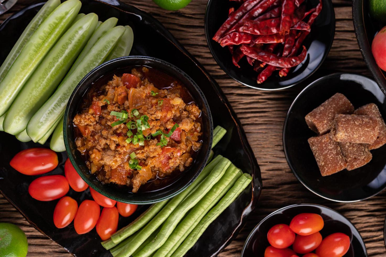 süßes Schweinefleisch mit Gurken, langen Bohnen, Tomaten und Beilagen foto