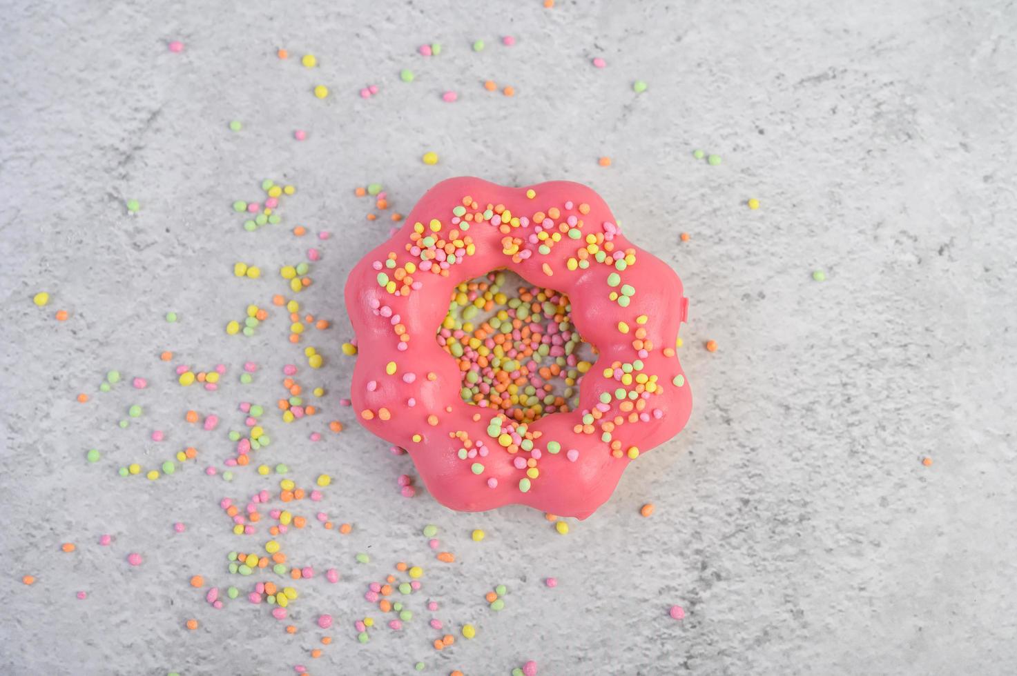 Erdbeer Donut mit Zuckerguss und Streuseln dekoriert foto