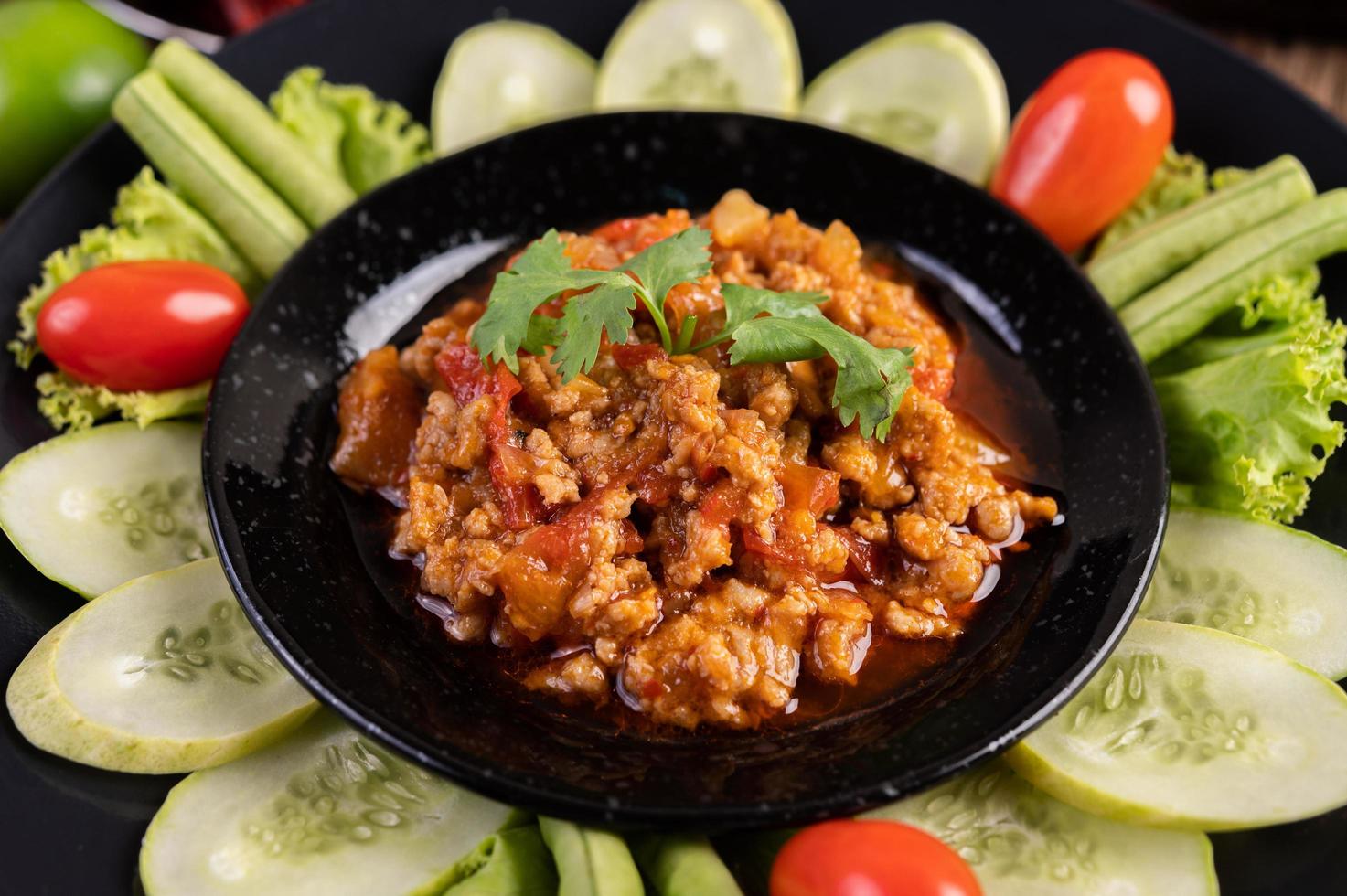 süße Schweinefleischschale mit Gurken, langen Bohnen und Tomaten foto