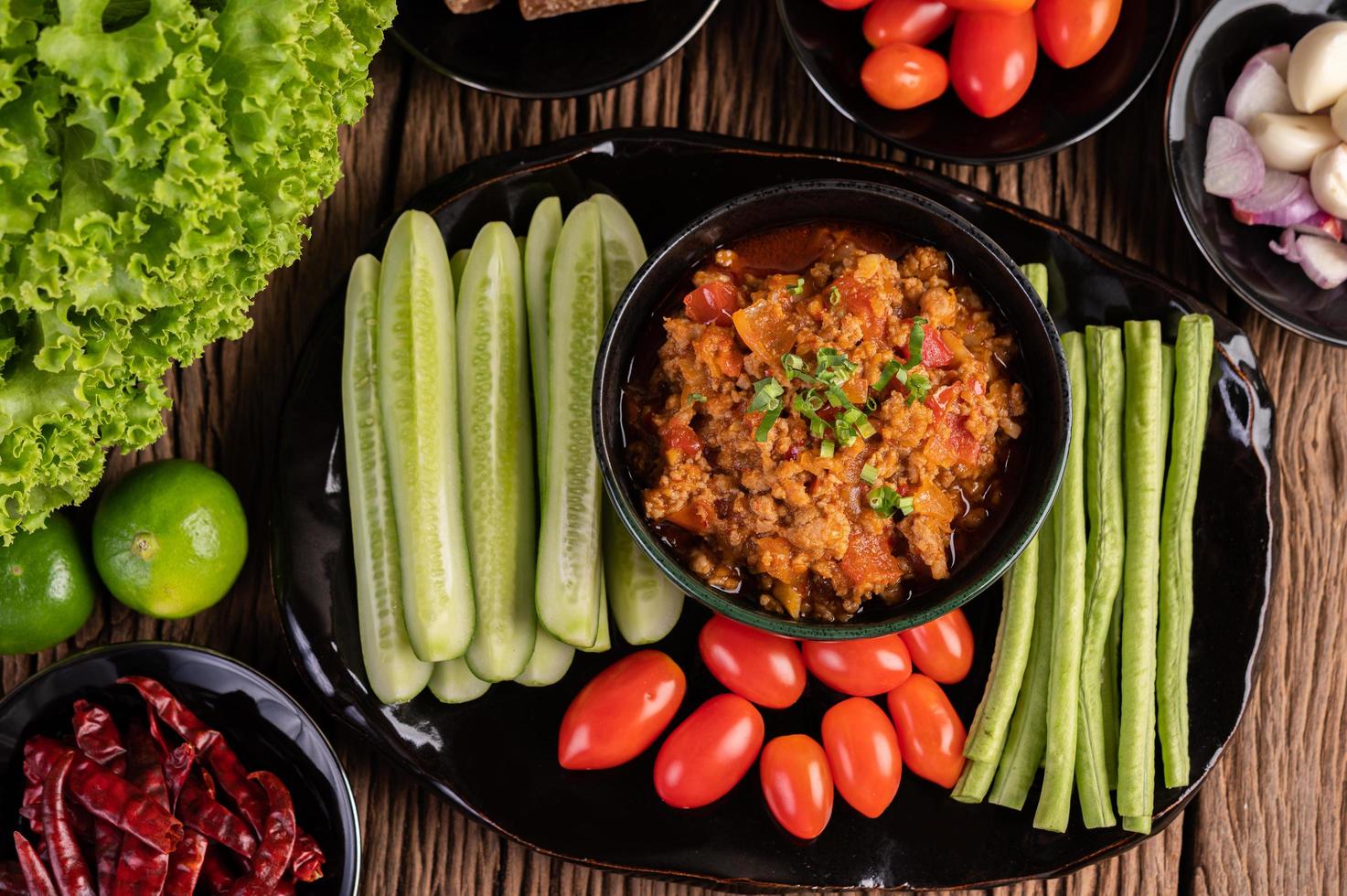 Schweinefleisch mit Gurken, langen Bohnen, Tomaten und Beilagen foto