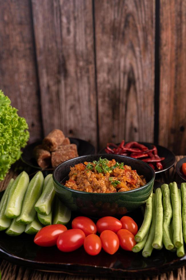 süße Schweinefleischschale mit Gurken, langen Bohnen und Tomaten foto