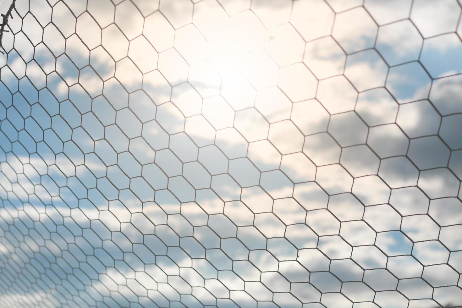 Detail des Fußballnetzes mit Sonnenlicht im Feldhintergrund, Fußballausrüstung foto