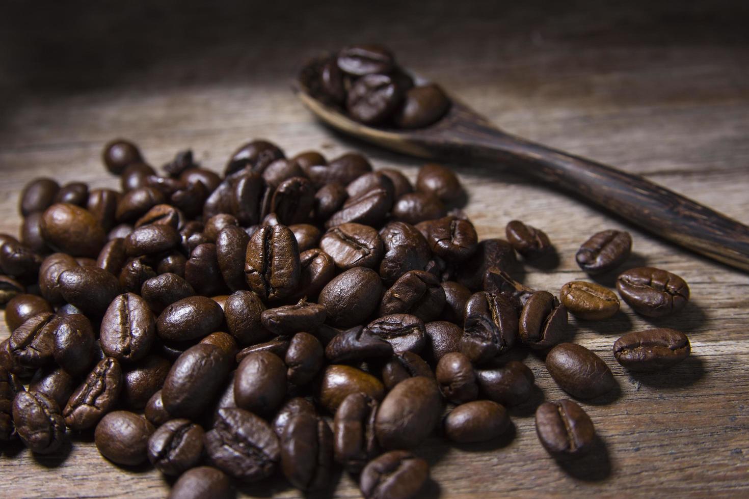 geröstete Kaffeebohnen und Holzlöffel foto