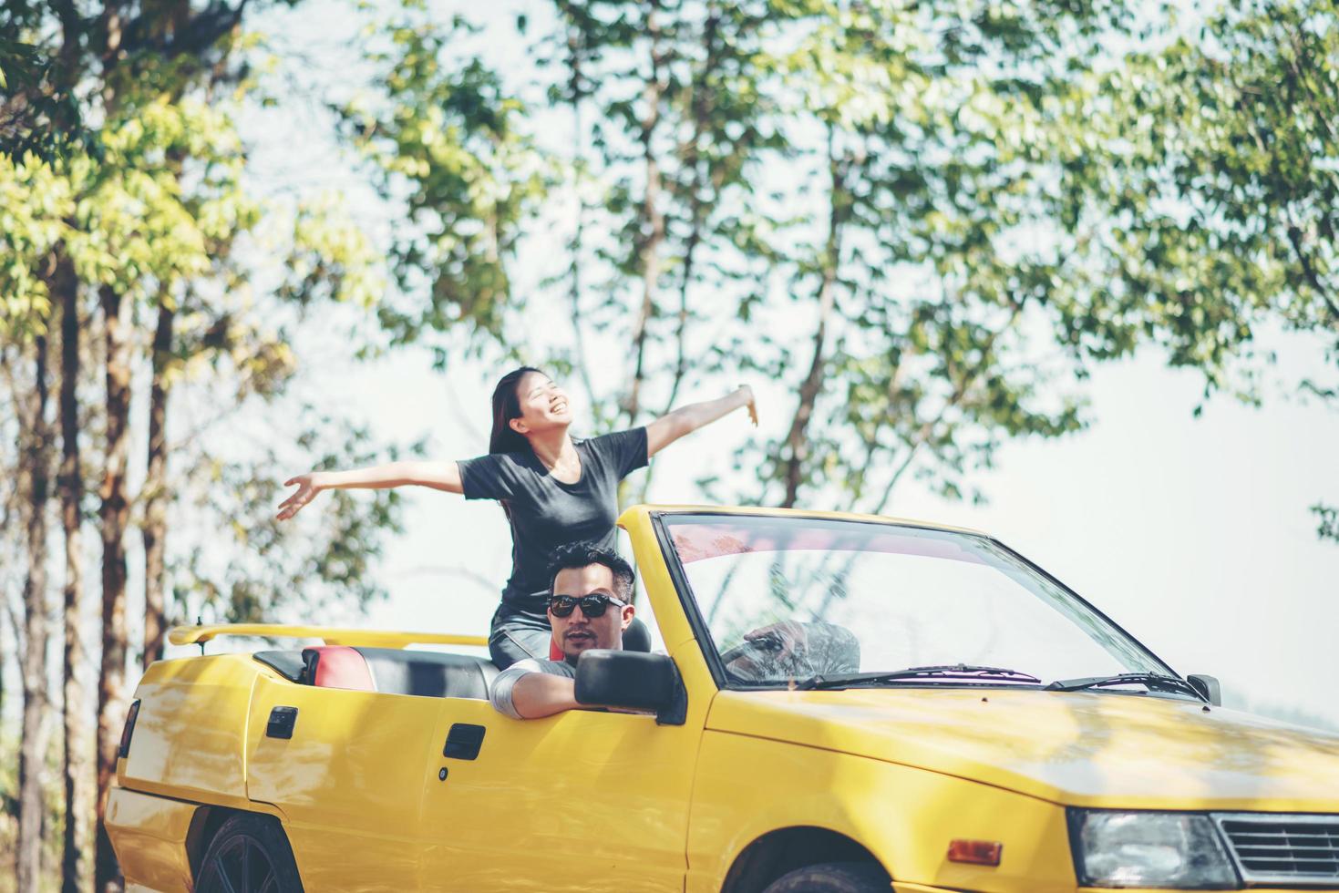 glückliches Paar, das das Verdeck unten im Cabrio genießt foto