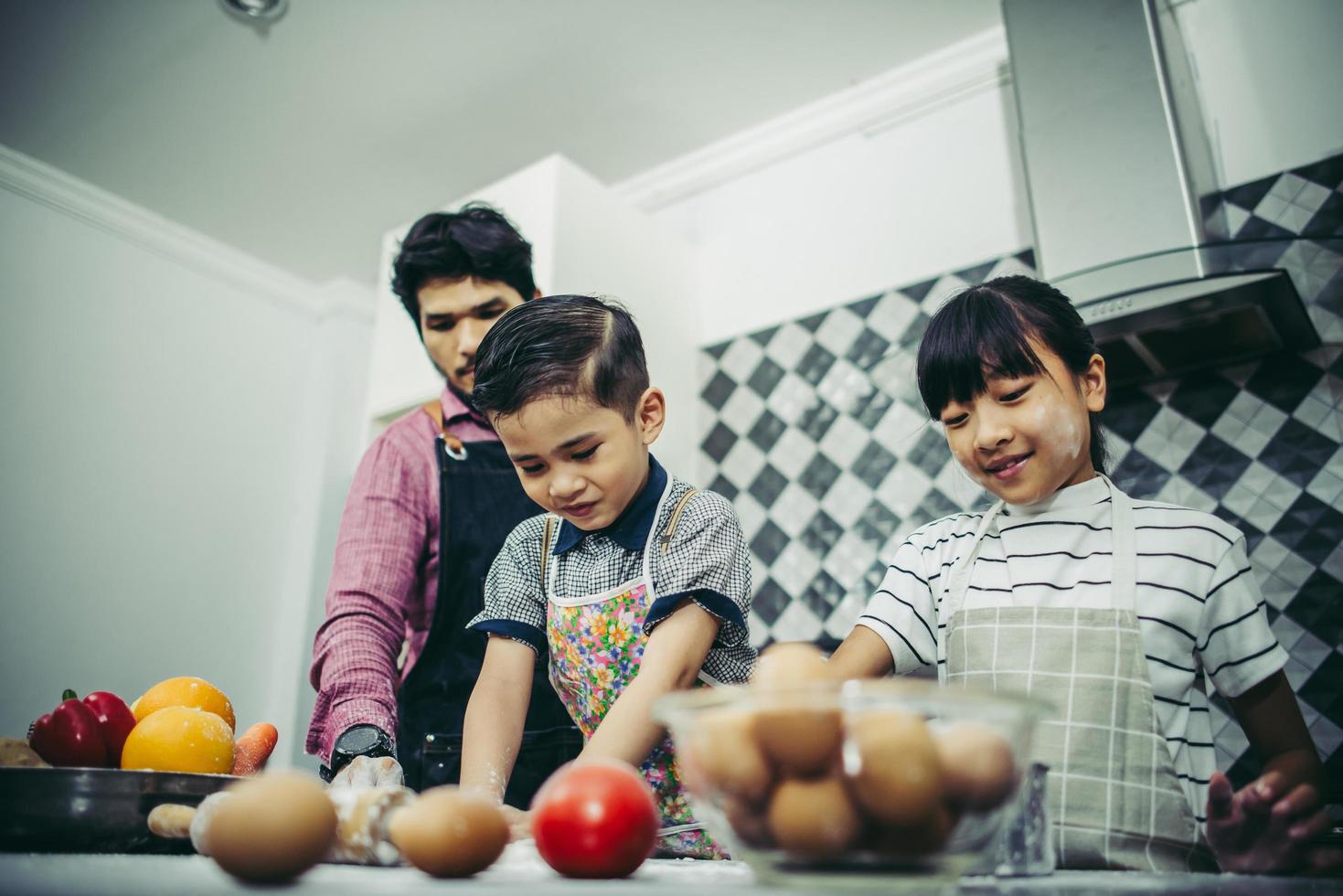 glückliche Familie, die zusammen in der Küche zu Hause kocht foto