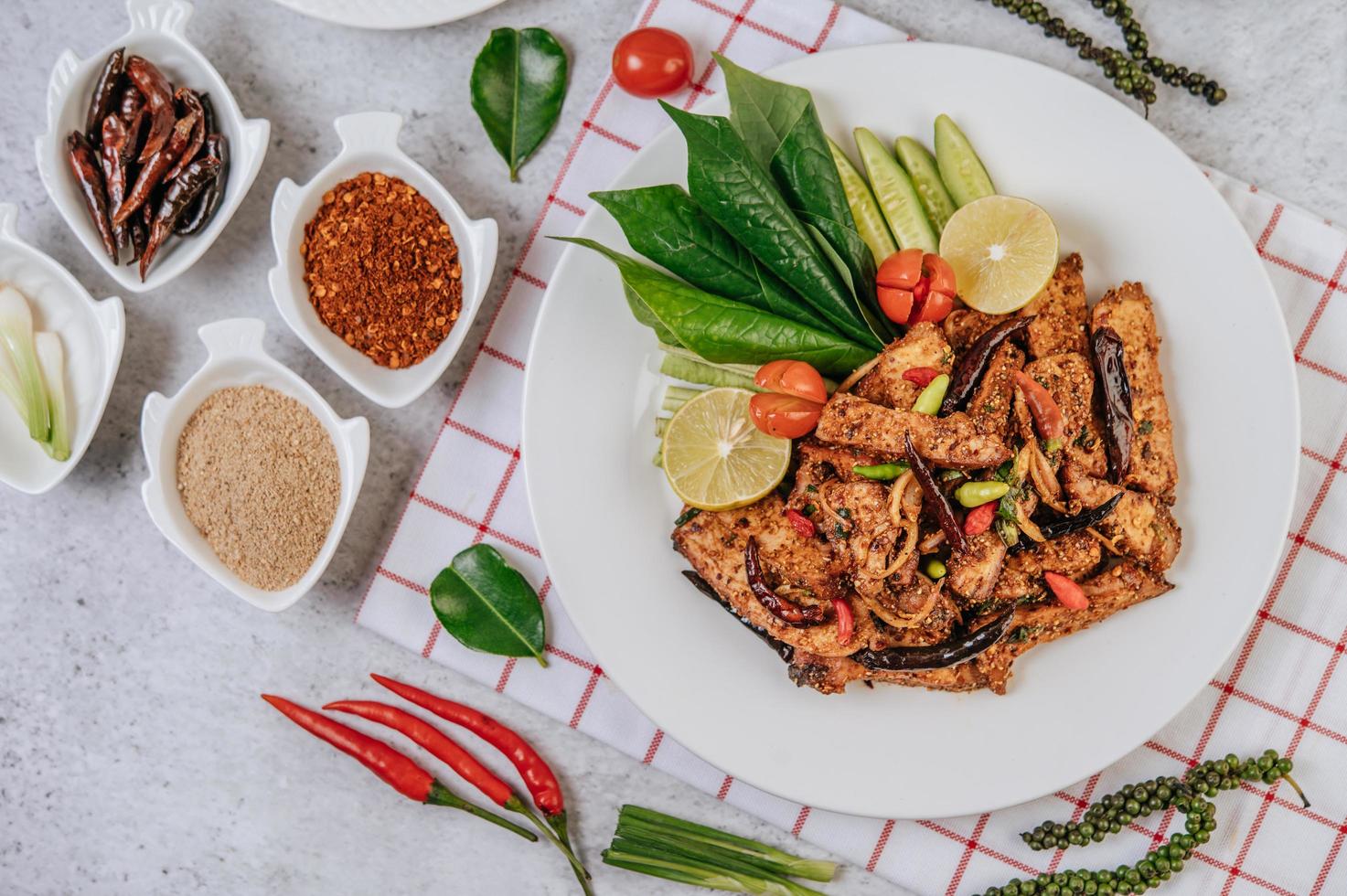 Schweinefleisch Nam Token mit gebratenem Chili, Tomate, Limette, Gurke und Pfeffer foto