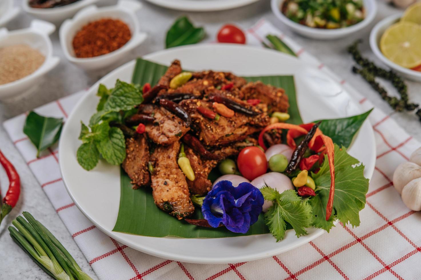 Schweinefleisch Nam Token mit gebratenem Chili, Tomate, Limette, Gurke und Pfeffer foto